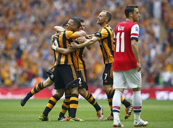 Hull City players celebrate with their team mate Chester after he scored his team's first goal, as Arsenal's Ozil reacts, during their FA Cup final soccer match at Wembley Stadium in London