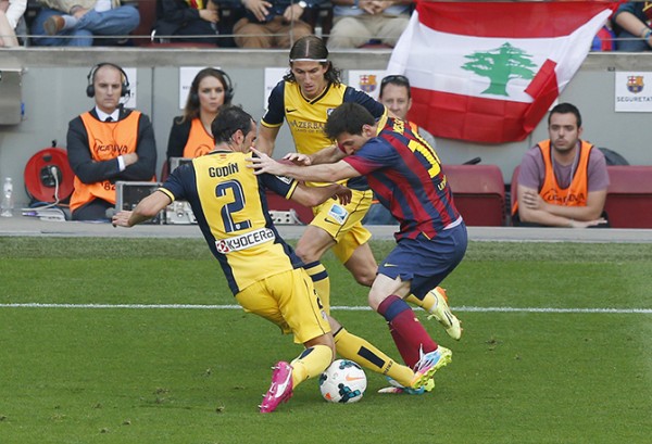 Barcelona's Messi is challenge by Atletico Madrid's Godin and Filipe Luis during their Spanish first division match in Barcelona