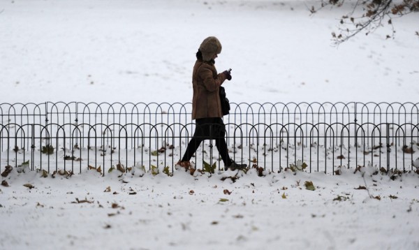 A woman uses her mobile phone as she wal