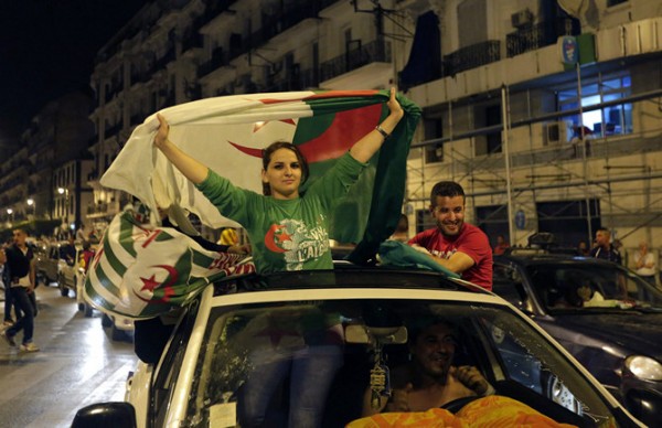 Algerian soccer fans hold their national flags as they celebrate after the end of Algeria's 2014 World Cup Group H match against Russia, in Algiers