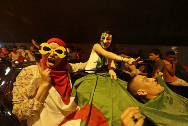Fans celebrate with an Algerian national flag after the end of Algeria's 2014 World Cup Group H match against Russia, in Algiers