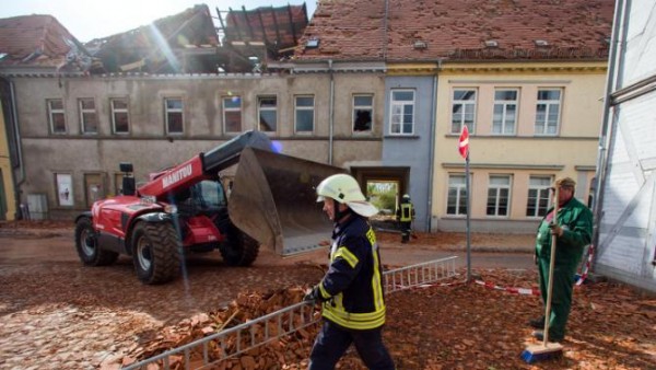 Fire fighters and helpers clear debris a day after a heavy storm hit the town of Buetzow, northeastern Germany, Wednesday, May 6, 2015. A heavy storm caused substantial damage in northern Germany. (Jens Buettner/dpa via AP)