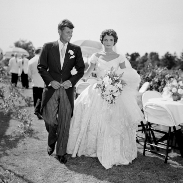 A scene from the Kennedy-Bouvier wedding. Groom John walks alongside his bride Jacqueline at an outdoor reception, 1953. Newport, Rhode Island. (Photo by Bachrach/Getty Images)