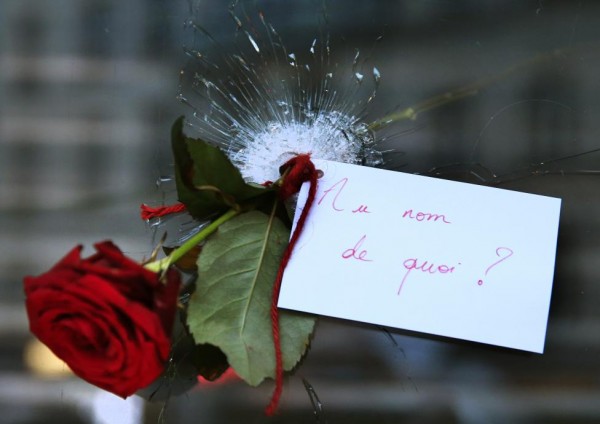 A rose placed in a bullet hole in a restaurant window the day after a series of deadly attacks in Paris, November 14, 2015. The note reads "In the Name of What?" REUTERS/Pascal Rossignol
