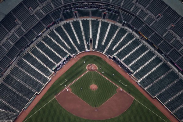 Camden Yards ballpark is seen without fans in this aerial image as a Baltimore Orioles player, wearing a white colored uniform, races towards home plate during the team's game against the Chicago White Sox in Baltimore, April 29, 2015. In what was a first for Major League Baseball, the Baltimore Orioles hosted the Chicago White Sox in a stadium closed to fans as Baltimore coped with some of the worst U.S. urban rioting in years.  REUTERS/Adrees Latif