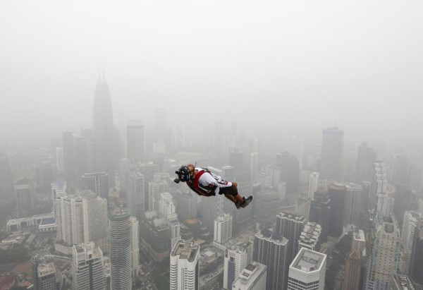 A BASE jumper leaps from the 300-metre high Kuala Lumpur Tower during the International Tower Jump in which more than 100 people take part, on a hazy day in Kuala Lumpur, Malaysia, October 2, 2015. REUTERS/Olivia Harris