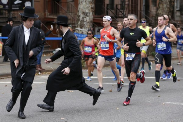 Orthodox Jewish men try to cross Bedford Avenue in the Williamsburg section of Brooklyn in front of former professional road racing cyclist Laurent Jalabert (runner in black ) of France, during the 2015 New York City Marathon, November 1, 2015. REUTERS/Shannon Stapleton