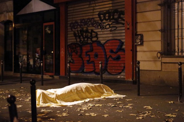 FOR USE AS DESIRED, YEAR END PHOTOS - FILE - A victim of a terrorist attack lies dead outside the Bataclan theater in Paris, Nov. 13, 2015.  (AP Photo/Jerome Delay, File)