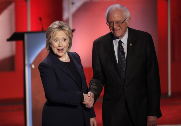 Hillary Clinton and Bernie Sanders shake hands on stage before the start. REUTERS/Mike Segar