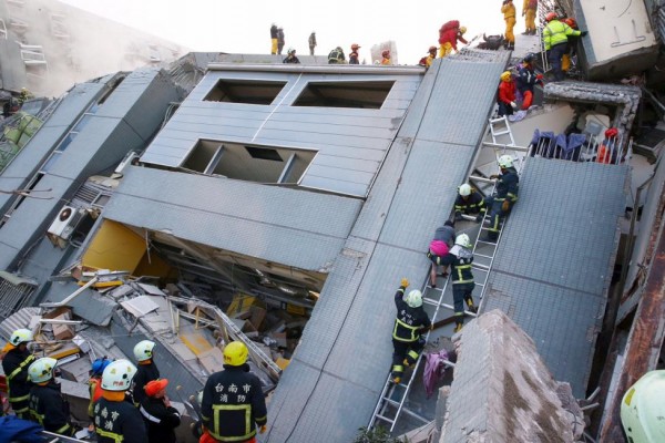 Rescue workers remove people from the site where a 17-storey apartment building collapsed after an earthquake hit Tainan, February 6, 2016. REUTERS/Stringer