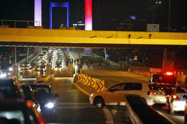 Turkish soldiers block the Istanbul's iconic Bosporus Bridge, lit in the colours of the French flag in solidarity with the victims of Thursday's attack in Nice, France, Friday, July 15, 2016. Turkey's prime minister says a group within Turkey's military has engaged in what appeared to be an attempted coup. Binali Yildirim told NTV television: "it is correct that there was an attempt." (AP Photo/Emrah Gurel)