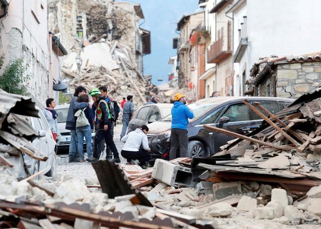 People stand along a road following a quake in Amatrice, central Italy, August 24, 2016. REUTERS/Remo Casilli