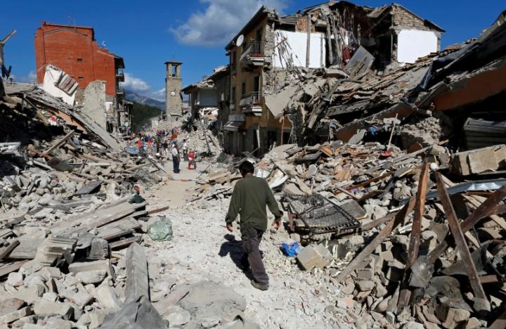 A man walks amidst rubble following an earthquake in Pescara del Tronto, central Italy, August 24, 2016. REUTERS/Remo Casilli