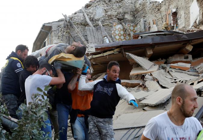 A man is carried away after having been rescued alive from the ruins following an earthquake in Amatrice, central Italy, August 24, 2016. REUTERS/Remo Casilli