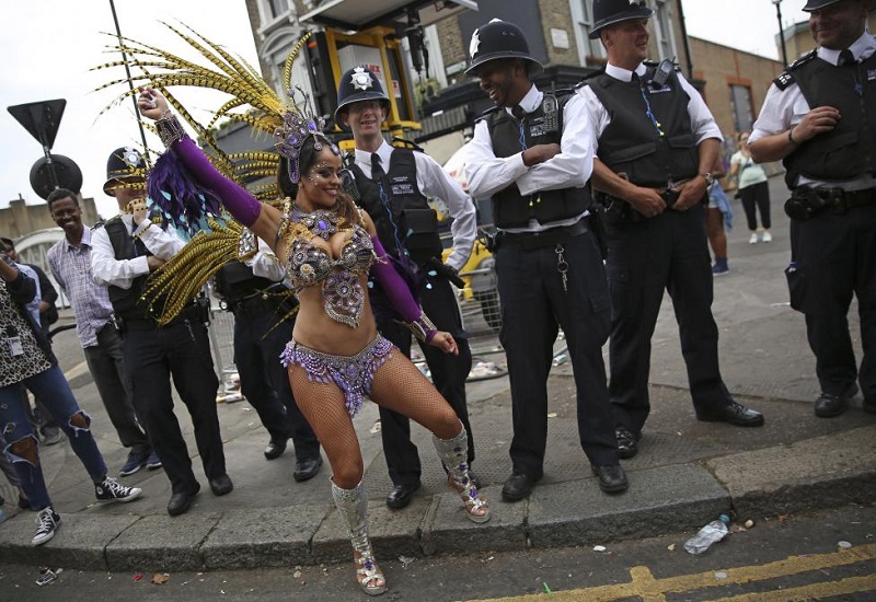 Police look as a performer dances during the Notting Hill Carnival in London, Britain August 29, 2016. REUTERS/Neil Hall