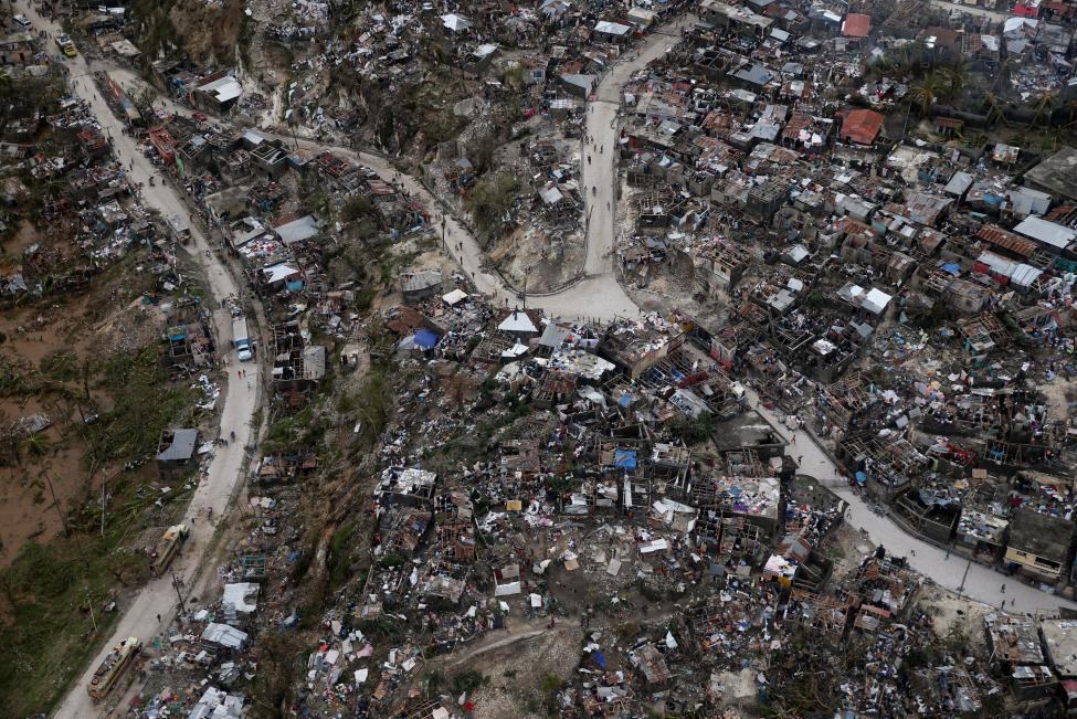 People walk down the streets next to destroyed houses after Hurricane Matthew passes Jeremie, Haiti, October 5, 2016. REUTERS/Carlos Garcia Rawlins