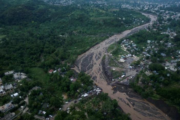 People gather next to a collapsed bridge after Hurricane Matthew passes Petit Goave, Haiti, October 5, 2016. REUTERS/Carlos Garcia Rawlins