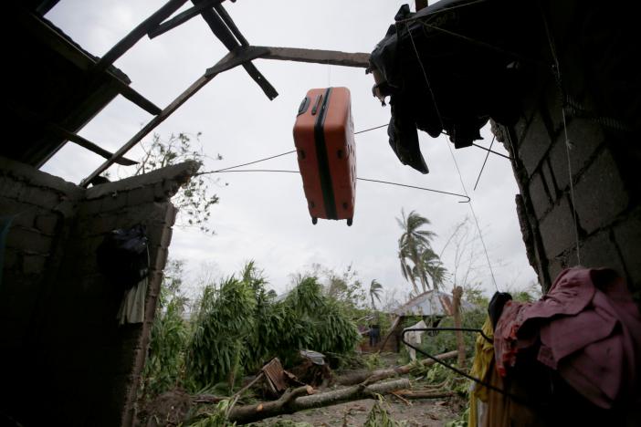 A suitcase hangs on the remains of the roof of a destroyed house by Hurricane Matthew in Les Cayes, Haiti, October 6, 2016. REUTERS/Andres Martinez Casares