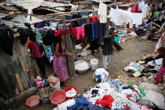 People wash their clothes in front of their partially destroyed houses after Hurricane Matthew passes Jeremie, Haiti, October 6, 2016. REUTERS/Carlos Garcia Rawlins