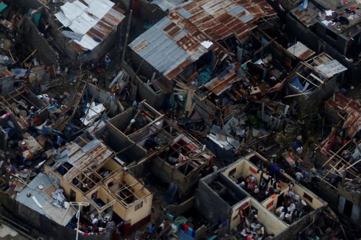 People walk next to destroyed houses after Hurricane Matthew passes Jeremie, Haiti. REUTERS/Carlos Garcia Rawlins