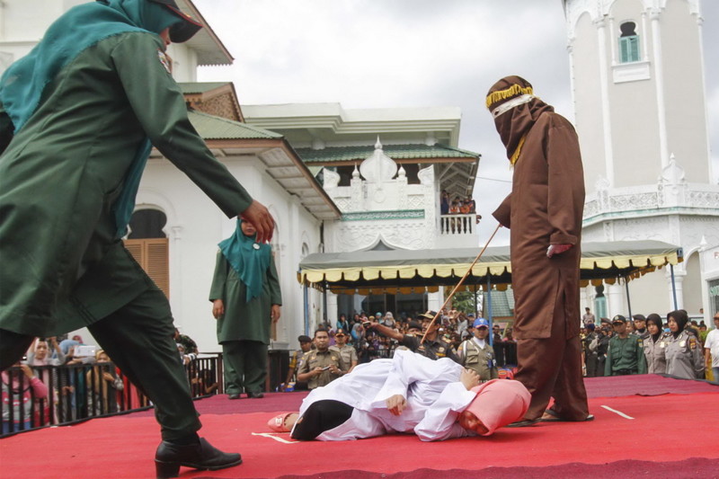 BANDA ACEH, INDONESIA - DECEMBER 28: An Indonesian Sharia police whips a women during a public caning ceremony outside Baiturrahim Mosque for violating Aceh's Sharia Laws on December 28, 2015 in Banda Aceh, Indonesia. PHOTOGRAPH BY Jefta Images / Barcroft Media UK Office, London. T +44 845 370 2233 W www.barcroftmedia.com USA Office, New York City. T +1 212 796 2458 W www.barcroftusa.com Indian Office, Delhi. T +91 11 4053 2429 W www.barcroftindia.com *** Local Caption *** 02396913