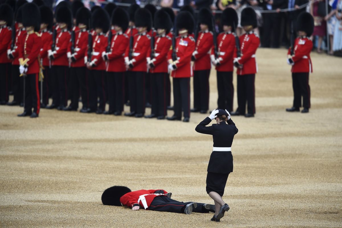 A Guardsman faints at Horseguards Parade for the annual Trooping the Colour ceremony in central London, Britain June 11, 2016. Trooping the Colour is a ceremony to honour Queen Elizabeth's official birthday. The Queen celebrates her 90th birthday this year. REUTERS/Dylan Martinez - RTX2FMUL