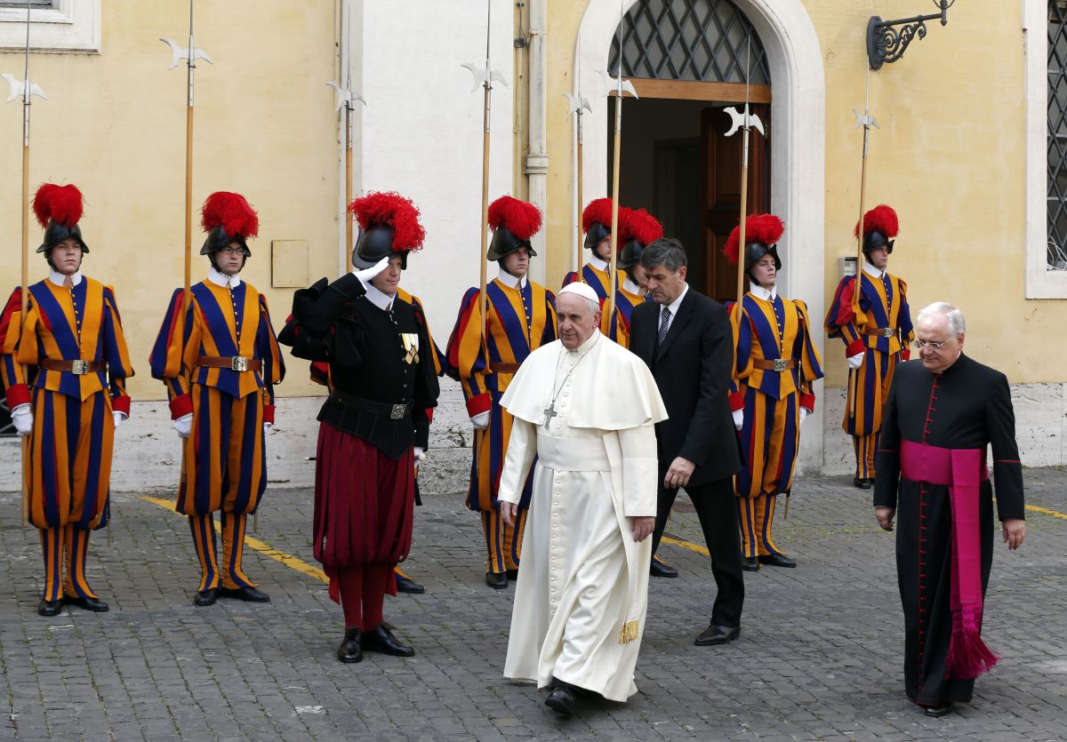 A Swiss guard salutes as Pope Francis walks to await the arrival of Britain's Queen Elizabeth at the Vatican April 3, 2014. REUTERS/Alessandro Bianchi (VATICAN - Tags: RELIGION ROYALS ENTERTAINMENT) - RTR3JSKE